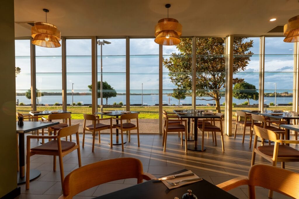 Waterfront dining area with wooden chairs and water views at VIVO Bar and Table, Port Macquarie