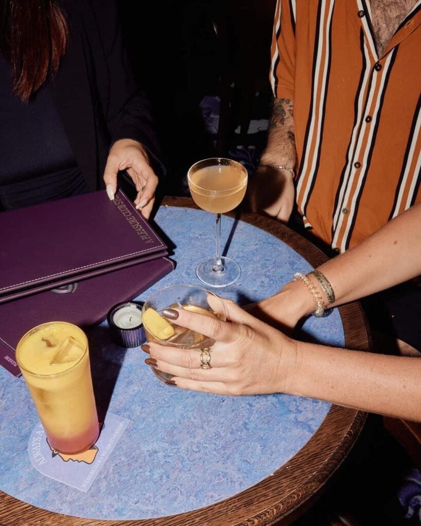 People handling menus and cocktails at Pleasure Club in Newtown.