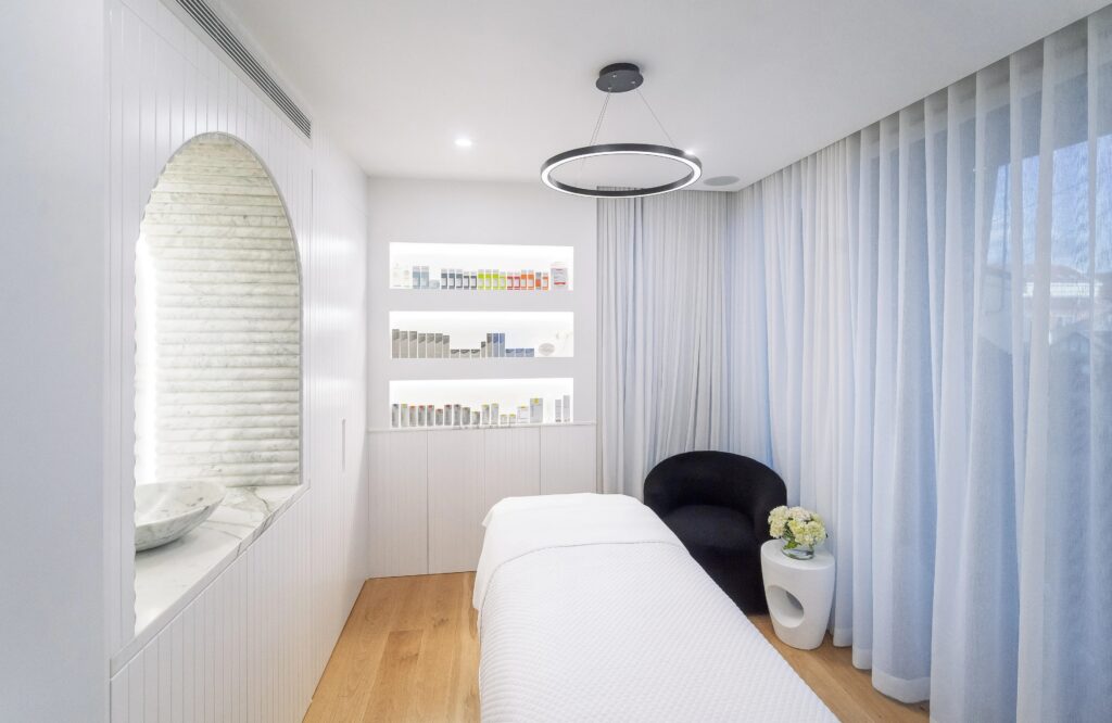 Private facial treatment room with marble basin, treatment bed and cosmeceutical skincare shelves at Merakii Beauty Room skin clinic, Bondi Sydney
