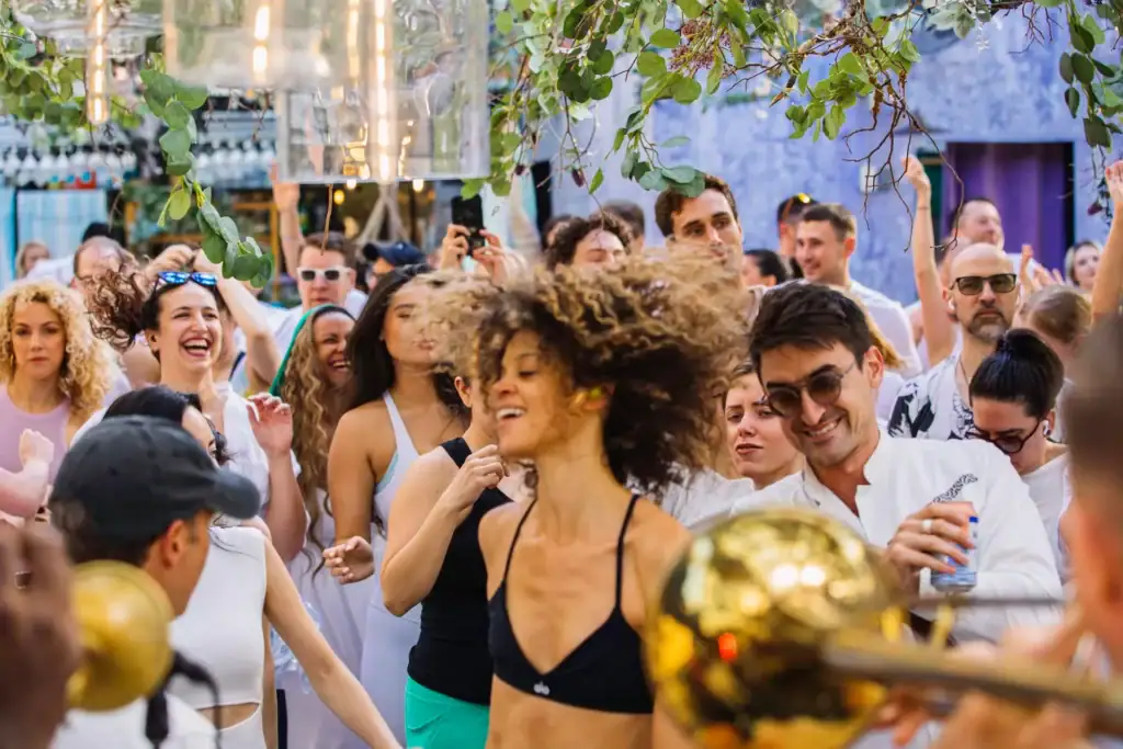 A group of people dancing in the daylight at DAYBREAKER, a sober dance party.