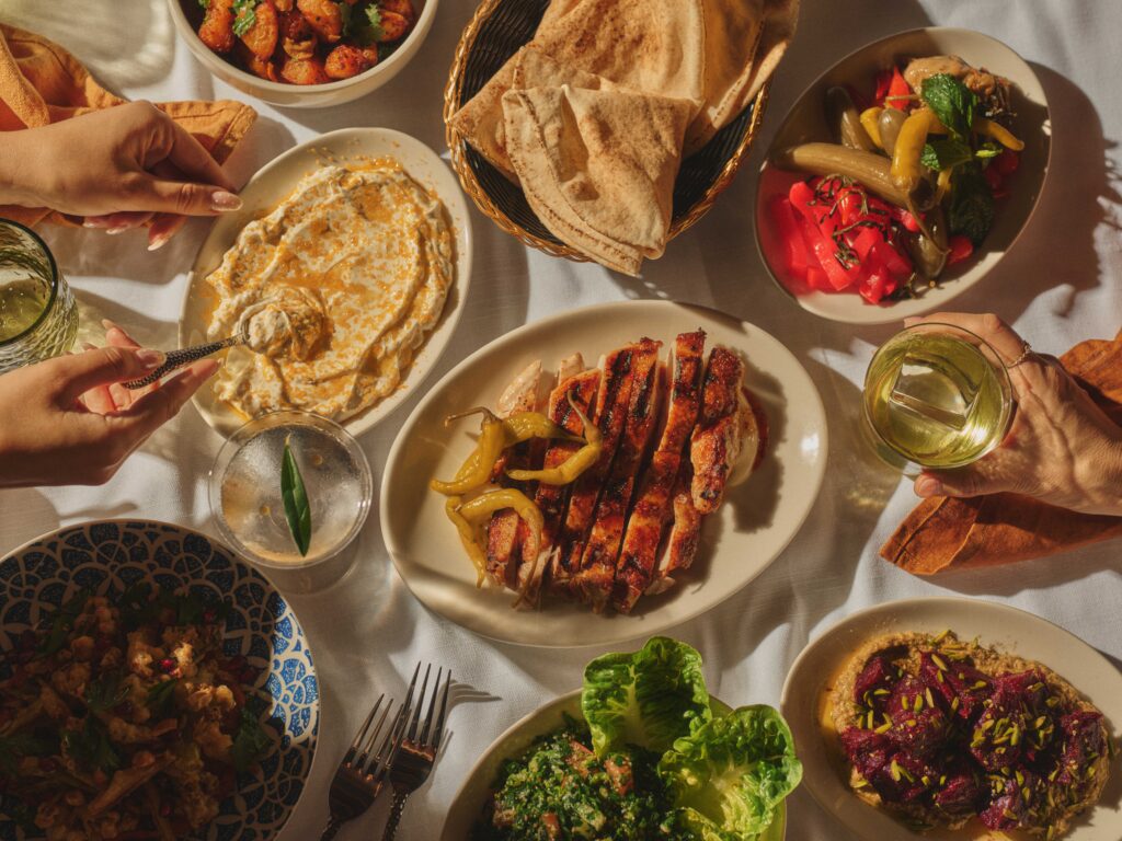 Farrouj half chicken with hummus pita bread tabbouleh pickles and mezze spread at Sahtein The Rocks Sydney