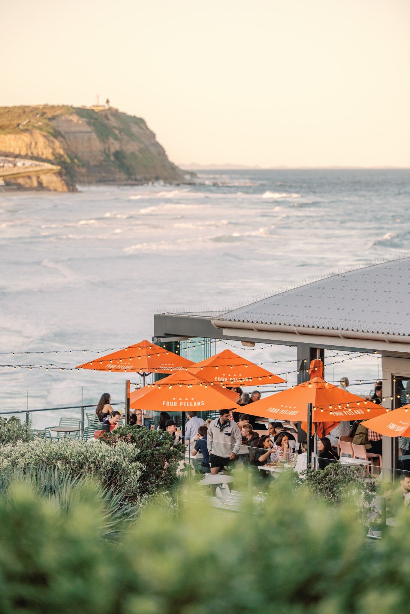Diners under orange umbrellas on the terrace at Merewether Surfhouse, Newcastle