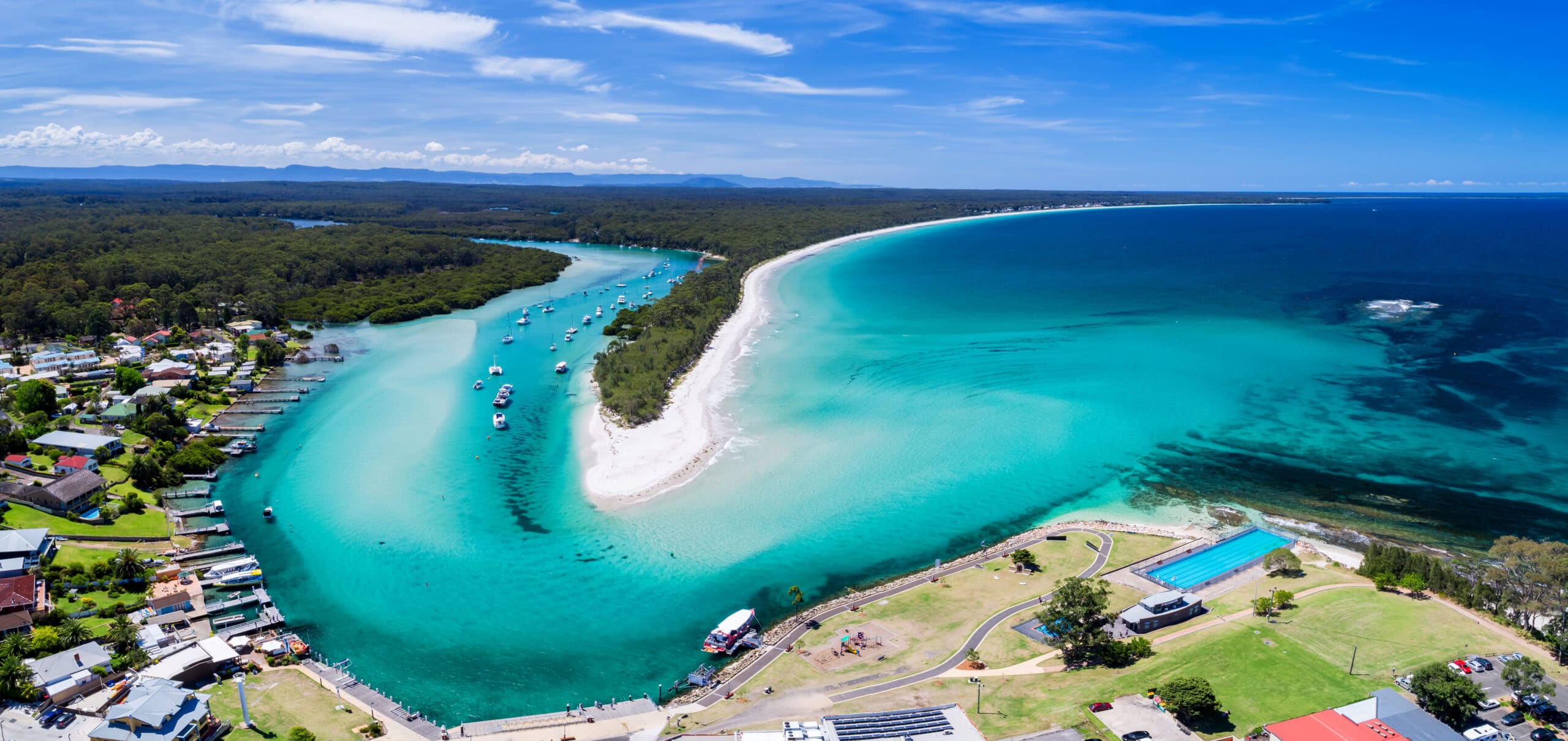 Aerial view of turquoise waterway white sand peninsula and coastal township at Huskisson Shoalhaven NSW South Coast