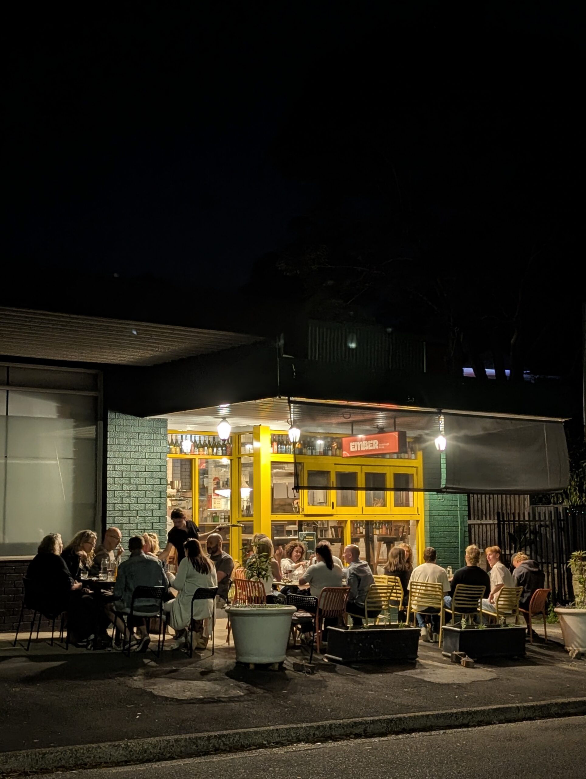 Diners outside Ember Pizza at night in Forestville Sydney