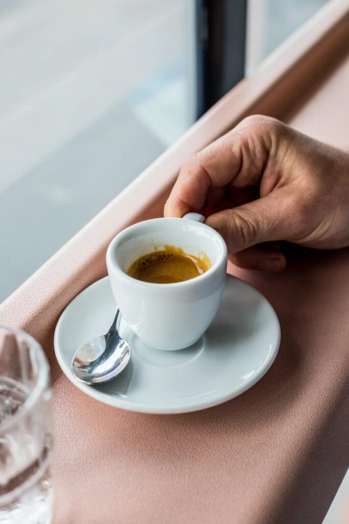 vacation coffee espresso on pink bench by a window