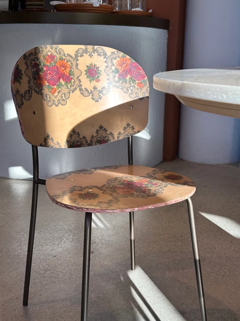 A patterned wooden chair in a slither of sun at sit in marrickville.
