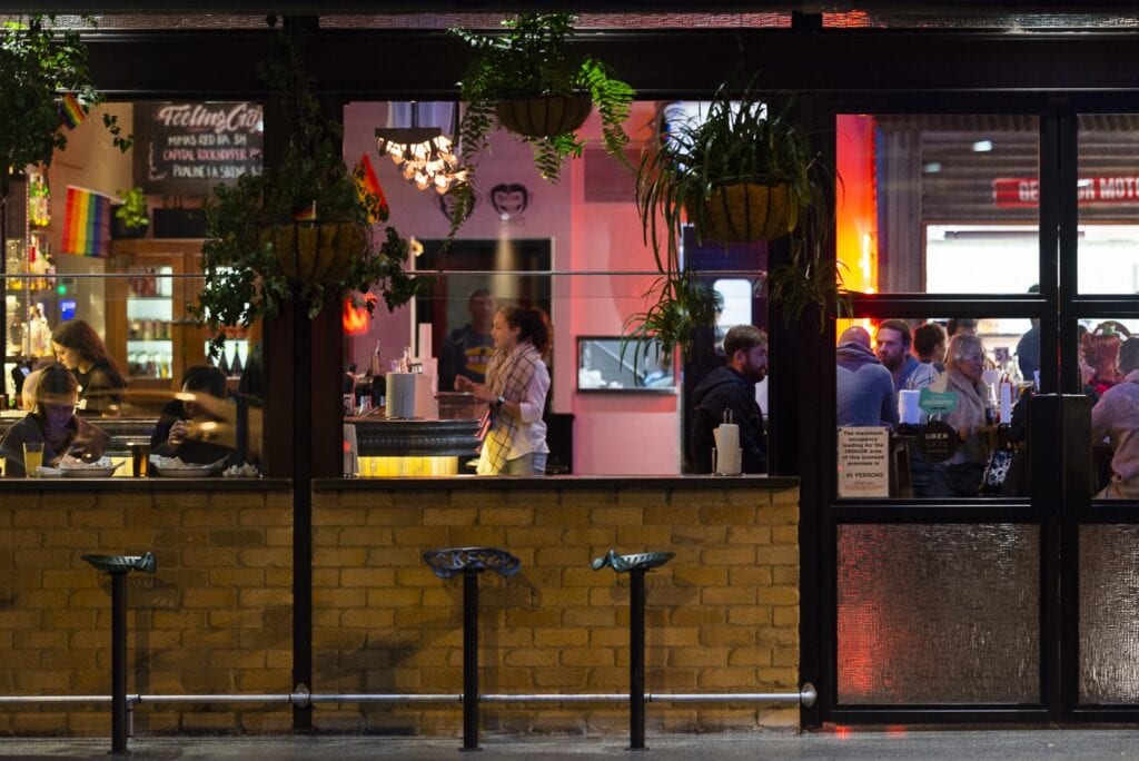 Braddon Lonsdale Street bar and restaurant strip at night with diners visible through glass windows Canberra