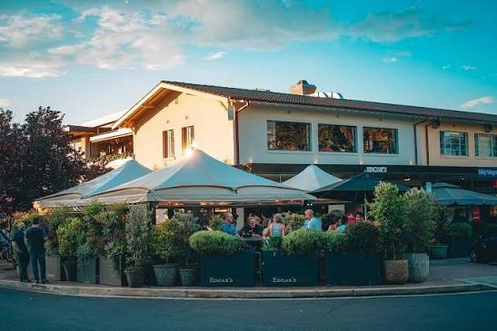 Edgar's Inn outdoor terrace exterior with white marquee umbrellas and diners at dusk Ainslie Canberra
