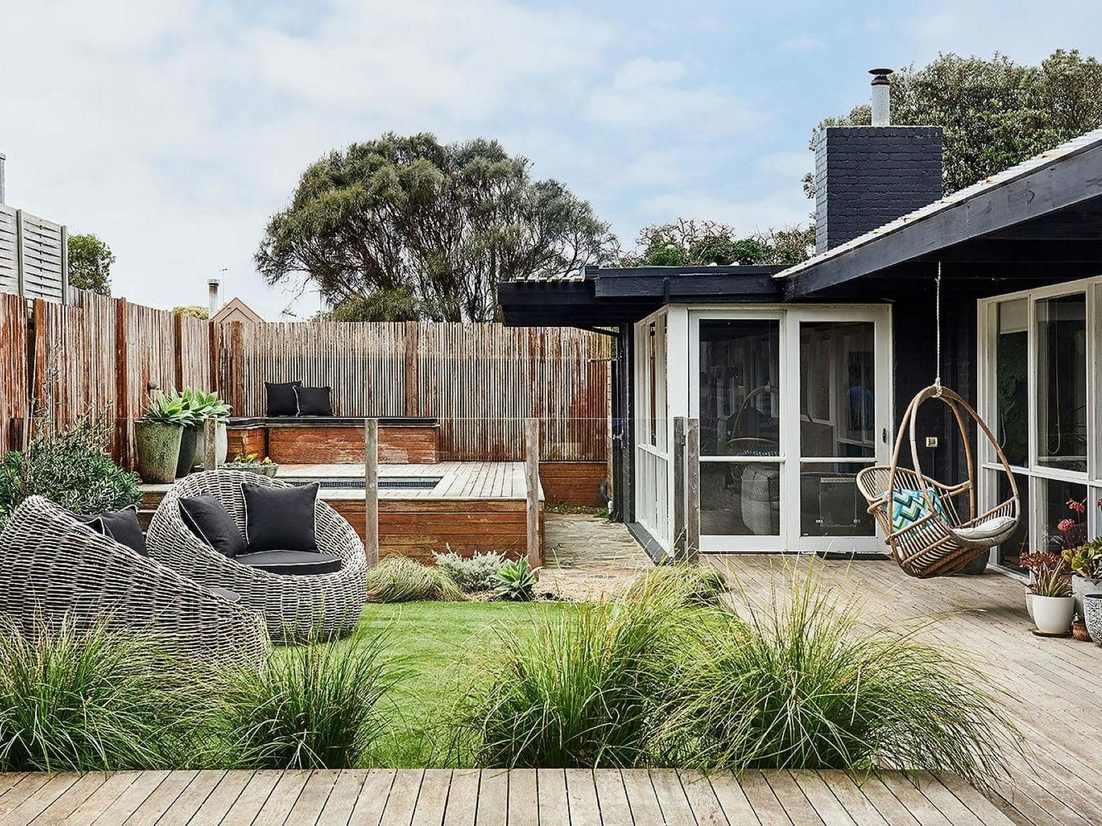Private garden and deck at 100 Steps to the Beach in Anglesea, with outdoor seating, landscaped greenery and a spa.
