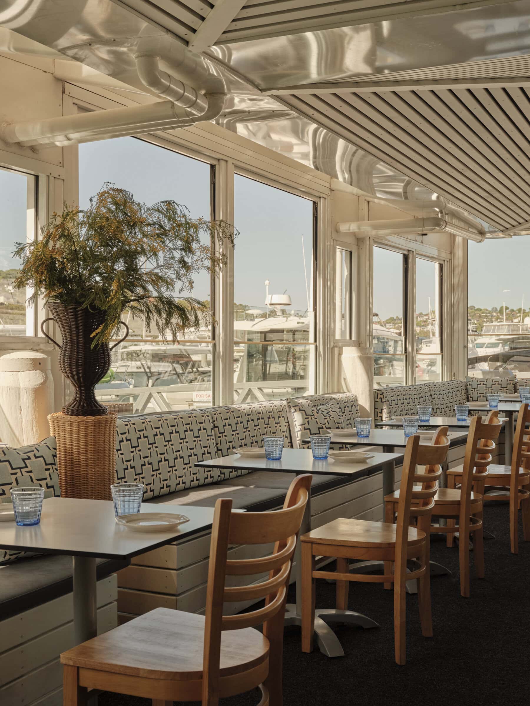 Waterfront dining room with marina view and patterned banquette seating at Chiosco by Ormeggio Mosman Sydney