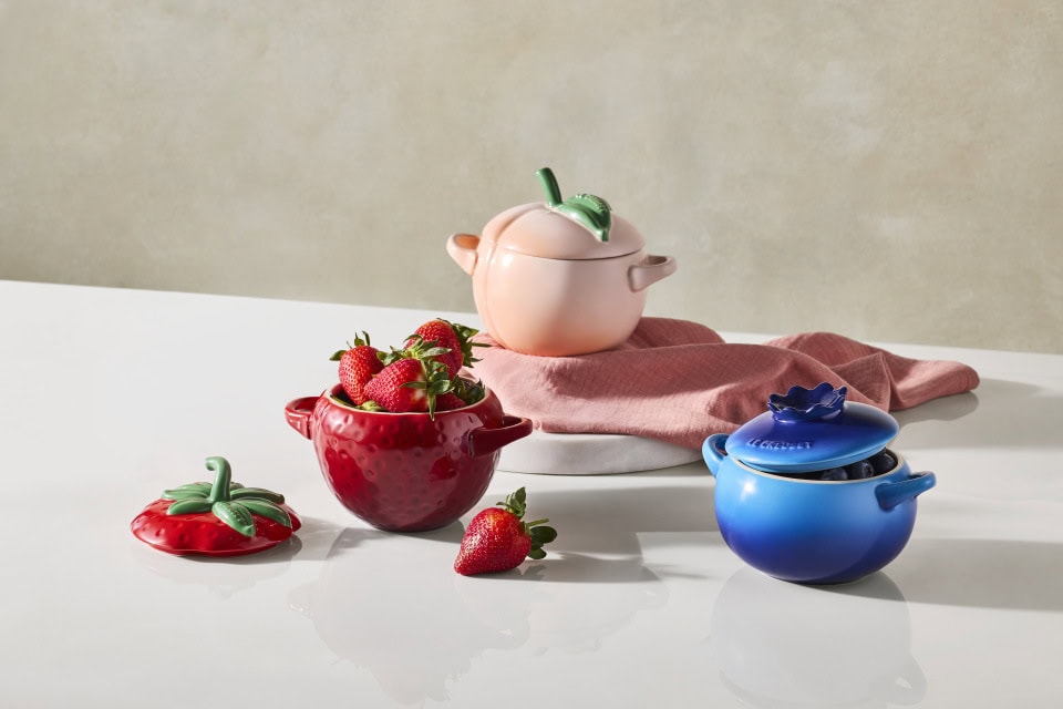 three le creuset fruit cocottes dishes in peach blueberry and strawberry