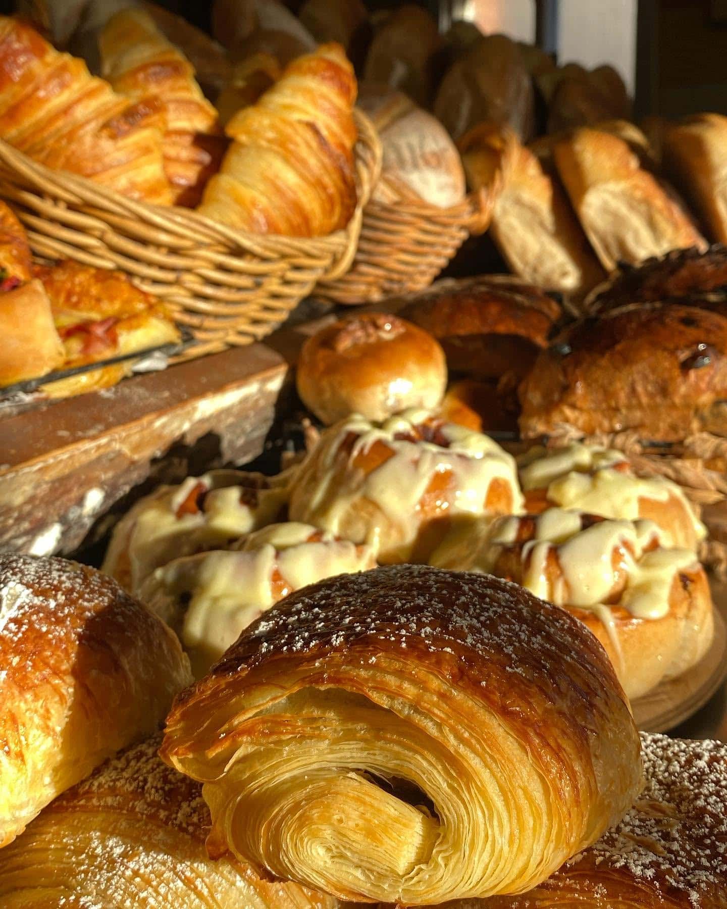 Assorted croissants and baked goods at a bakery display.