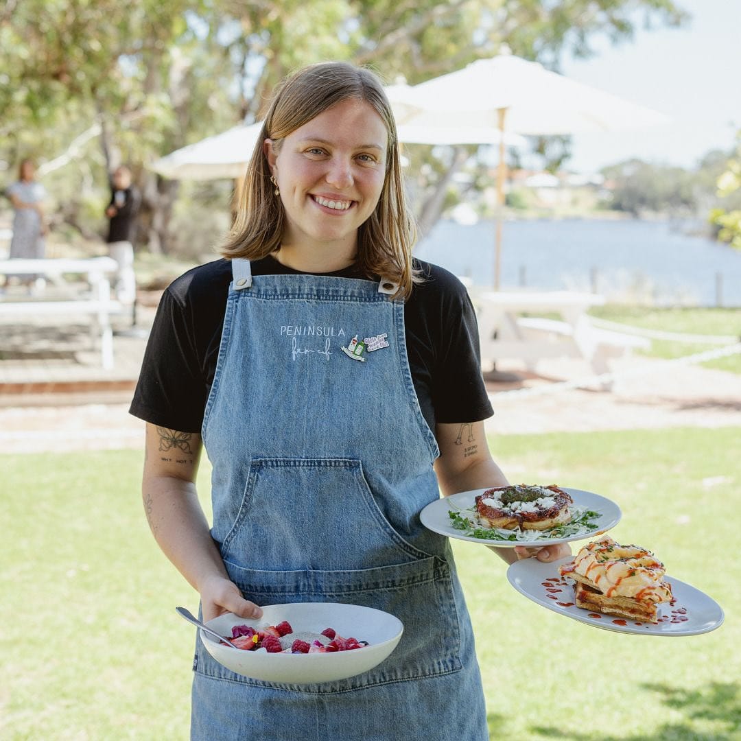 Staff member holding cafe food at Peninsular Farm Cafe
