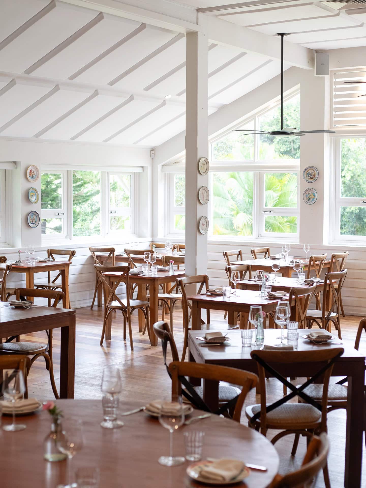 Light-filled dining room with timber tables and garden views at The Hut Possum Creek NSW
