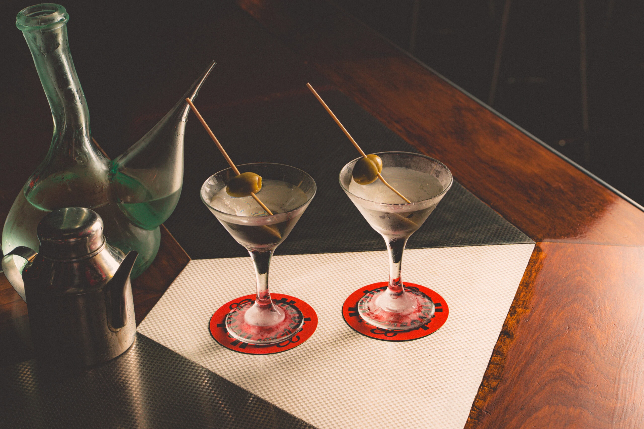 two martinis with olives sitting on a table