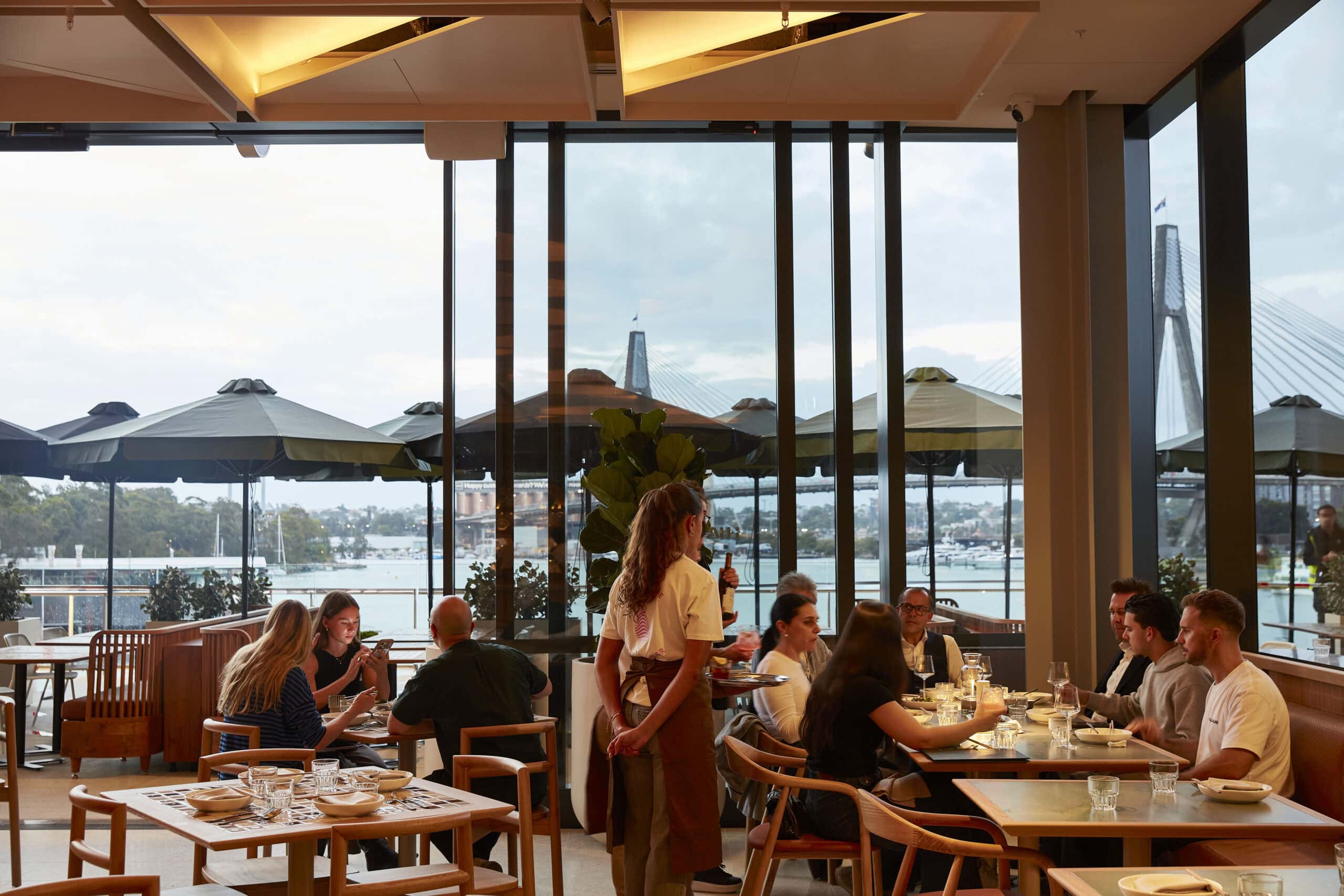 Dining room with floor to ceiling windows and Anzac Bridge view at Lua Pyrmont Sydney