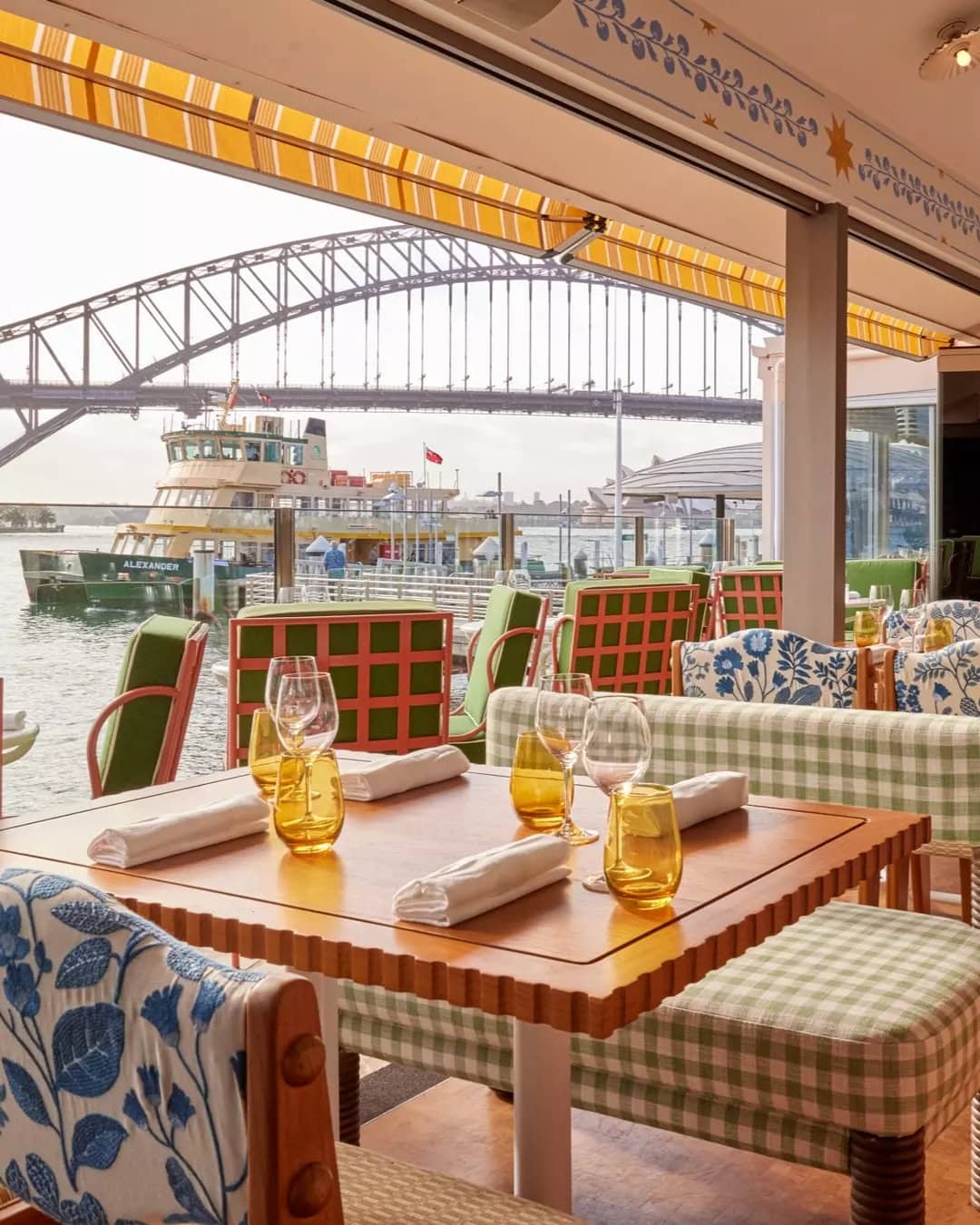 The colourful interiors of sails lavender bay's dining room, with the harbour bridge right in the background.