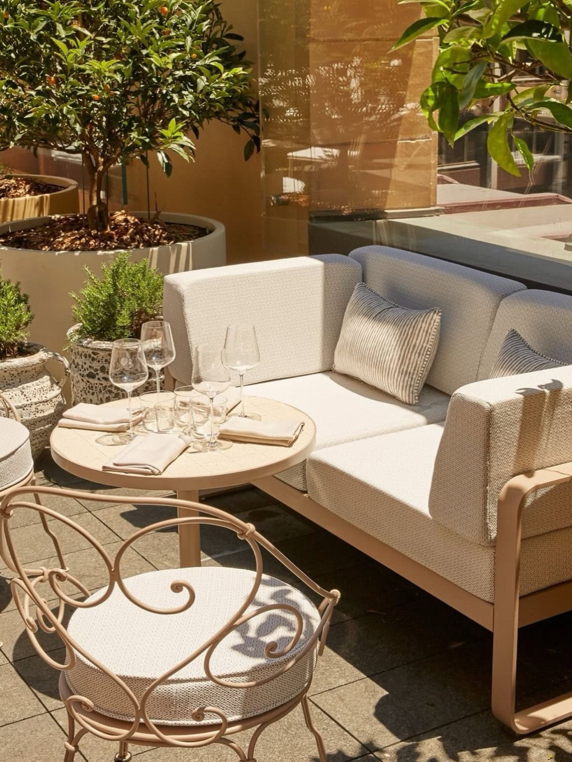 the terrace of shell house's bar featuring comfortable seating and a table set with wine glasses
