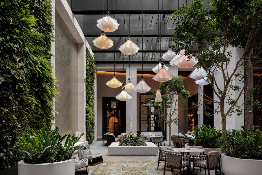 Luxury Sydney hotel Capella's atrium featuring their blooming flower instal and seating for aperture restaurant.