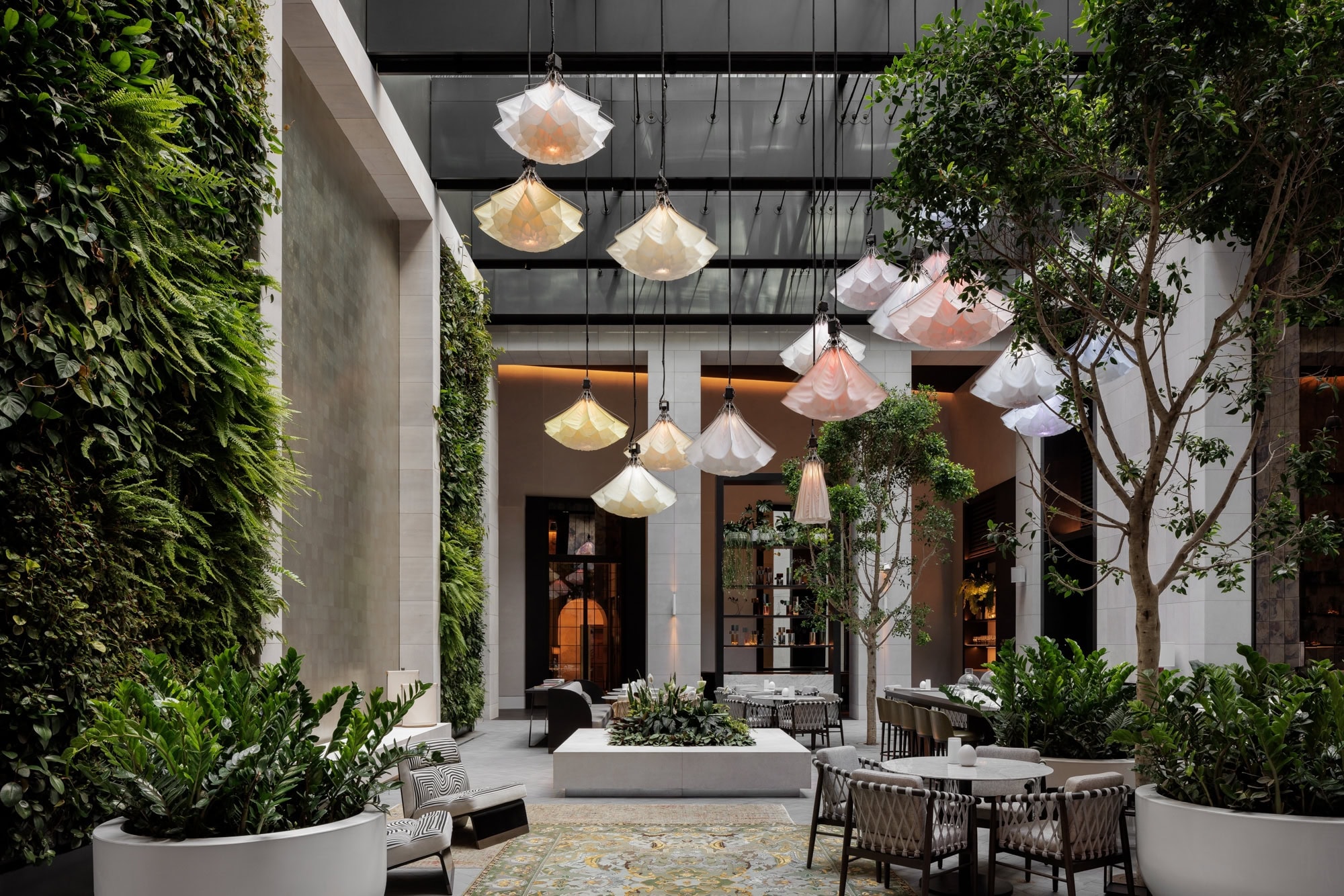 Luxury Sydney hotel Capella's atrium featuring their blooming flower instal and seating for aperture restaurant.