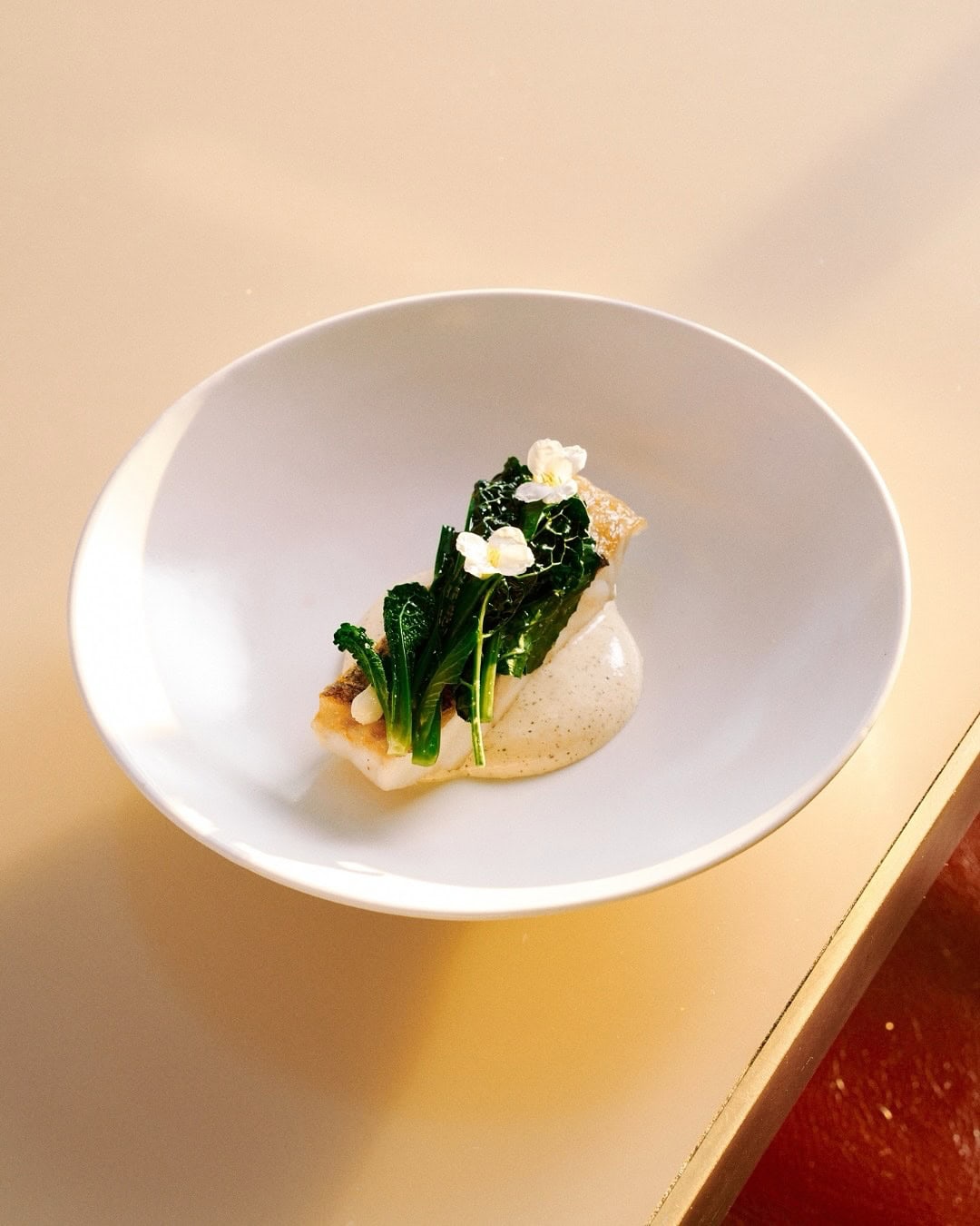 A delicately plated piece of Murray Cod, garnished with edible blooms, from Bennelong in Sydney.