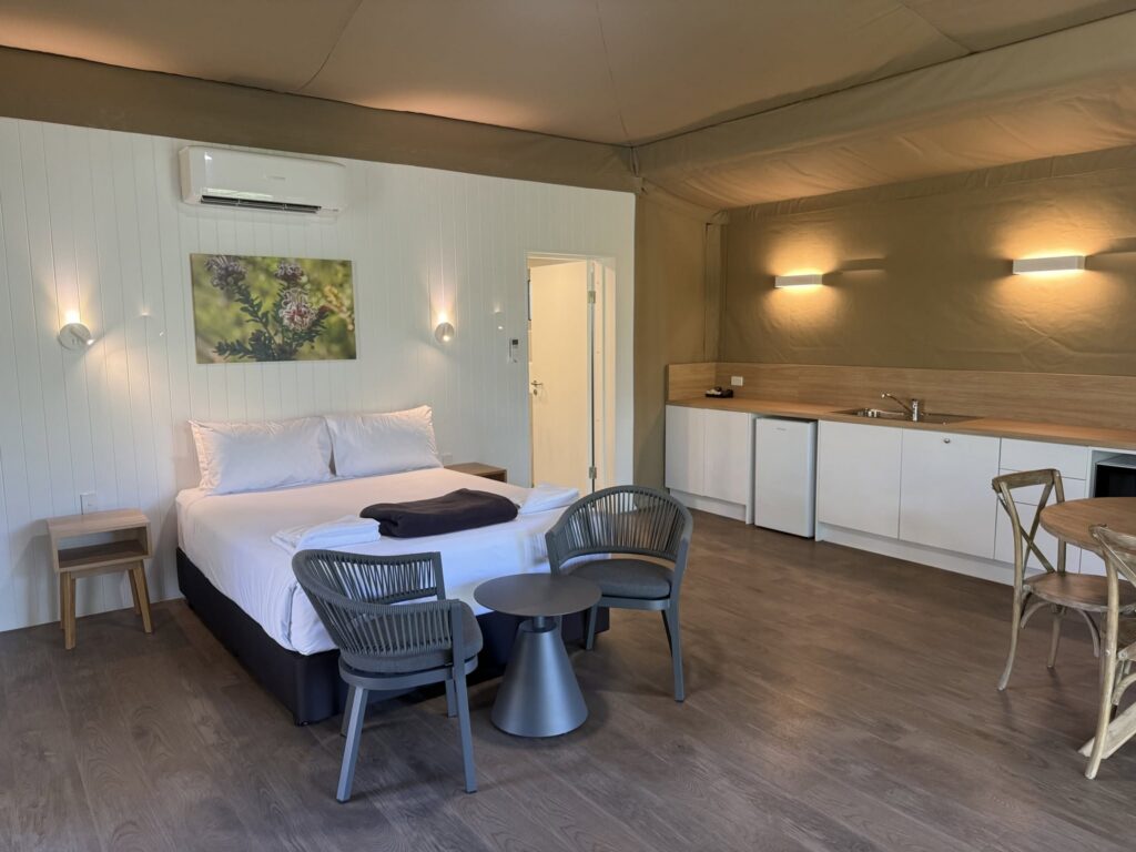 Glamping tent interior with queen bed and kitchenette at Discovery Parks Lane Cove Sydney