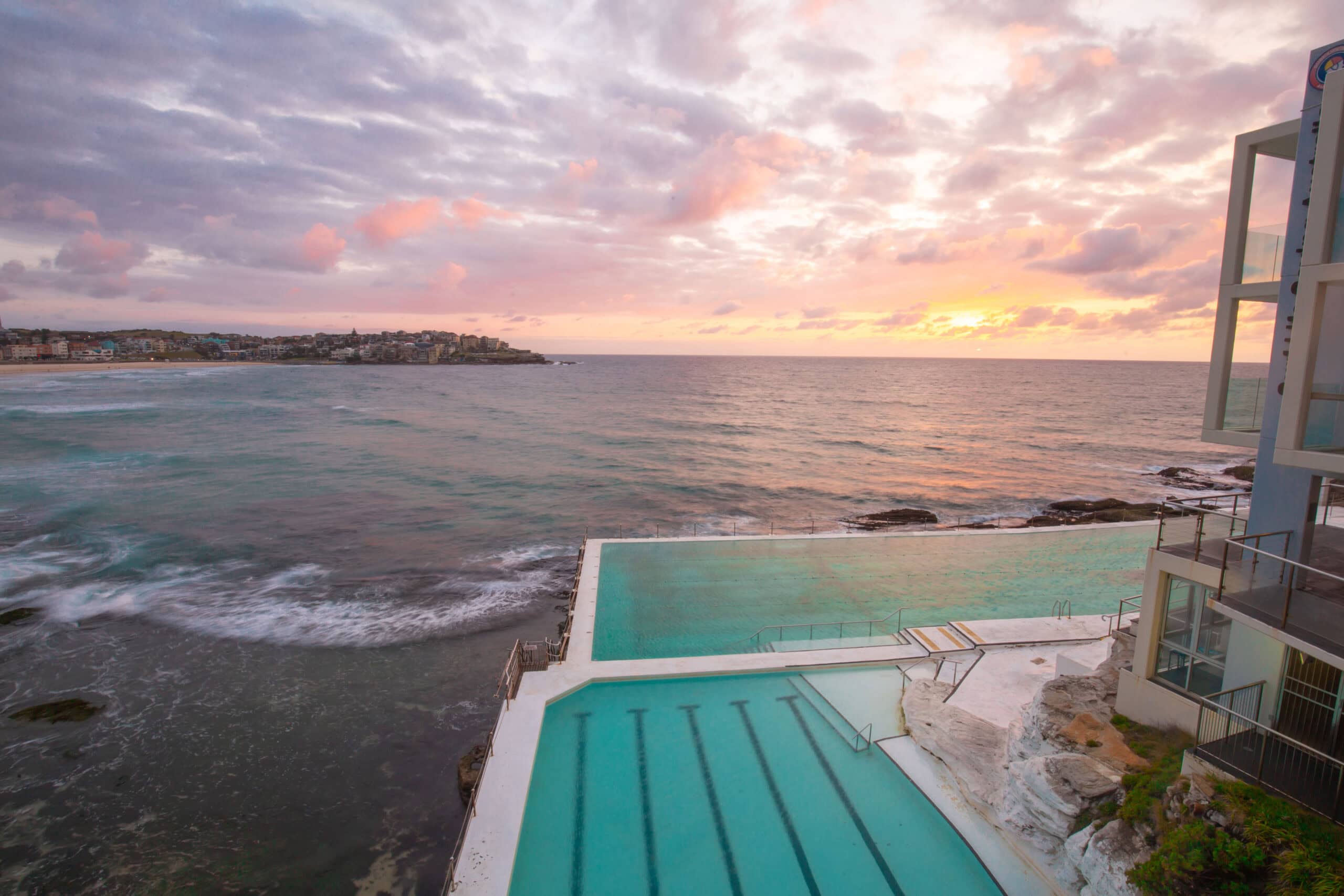 the sun setting over the famous bondi icebergs rock pool