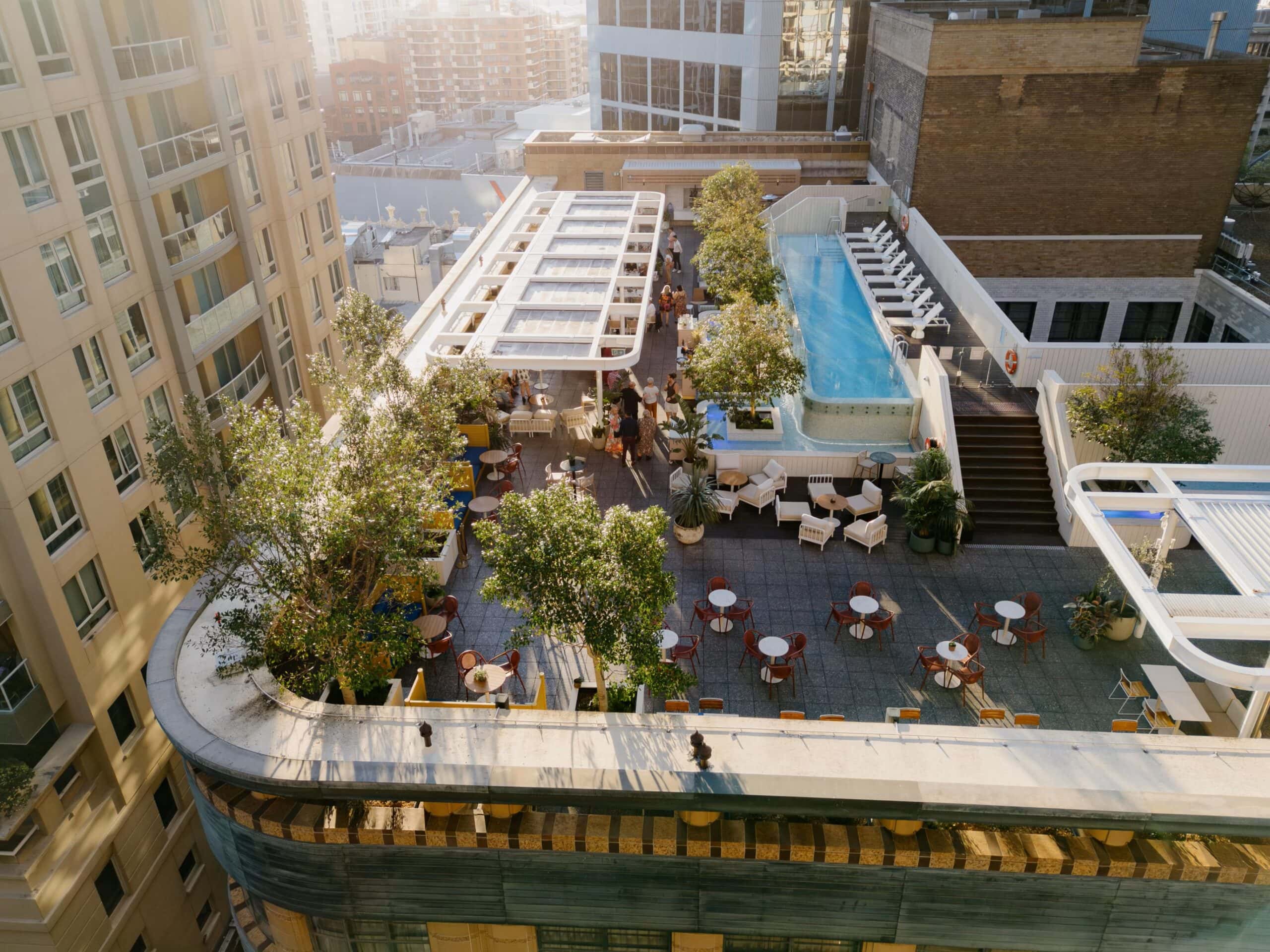 An aerial view of Kimpton Margot's rooftop pool with a stream of sunlight filtering down