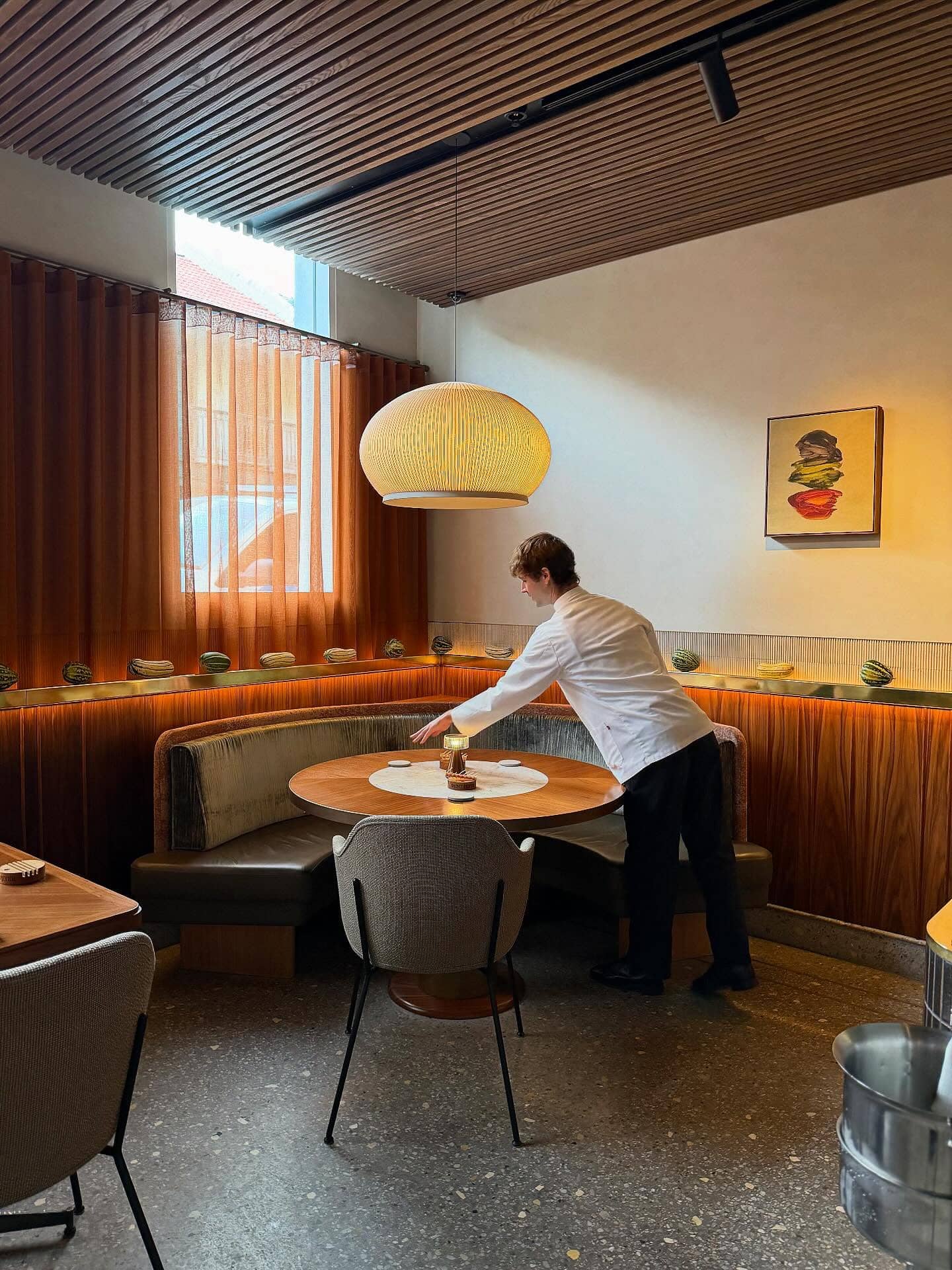 A waiter setting the table in Paddington seafood restaurant Saint Peter's minimalist dining room.