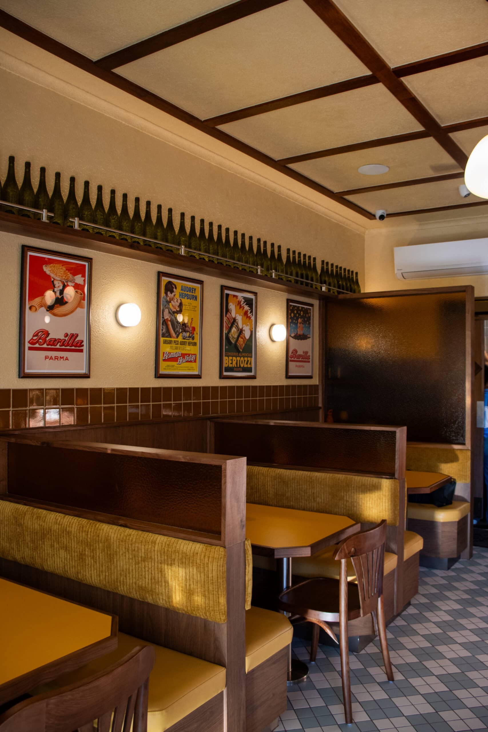 the interiors of sugo pasta bar with booth seating and wine bottles lining the wall