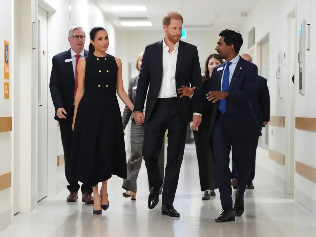 meghan markle duchess of sussex and prince harry making their first australian appearance, holding hands and walking