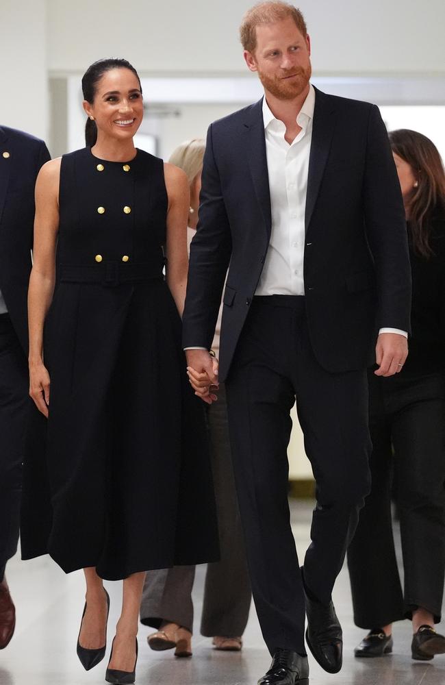 meghan markle duchess of sussex and prince harry making their first australian appearance, holding hands and walking
