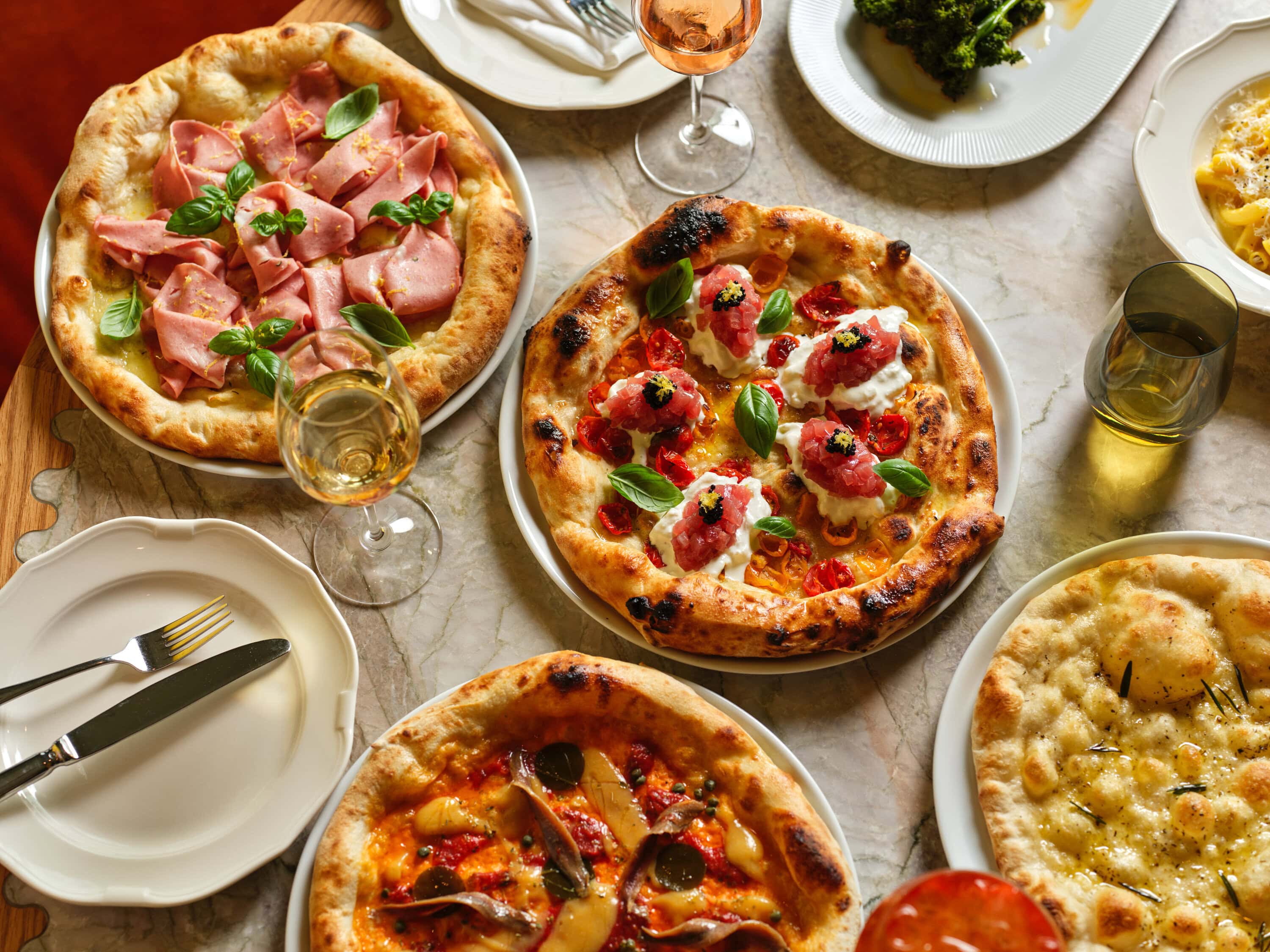 an aerial shot of various pizzas at pizza'mare including a cheesy garlic pizza and proscuitto pizza