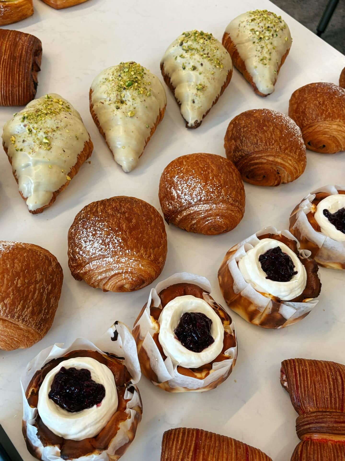 Assorted croissants and fruit-filled pastries on the counter at AM Bakehouse in Glen Iris, Melbourne.