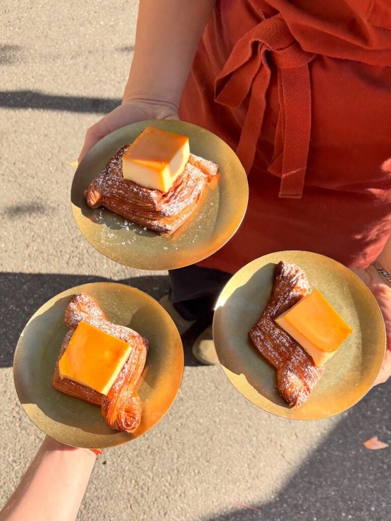 Three laminated pastries served on gold plates at Amann Patisserie in Melbourne.