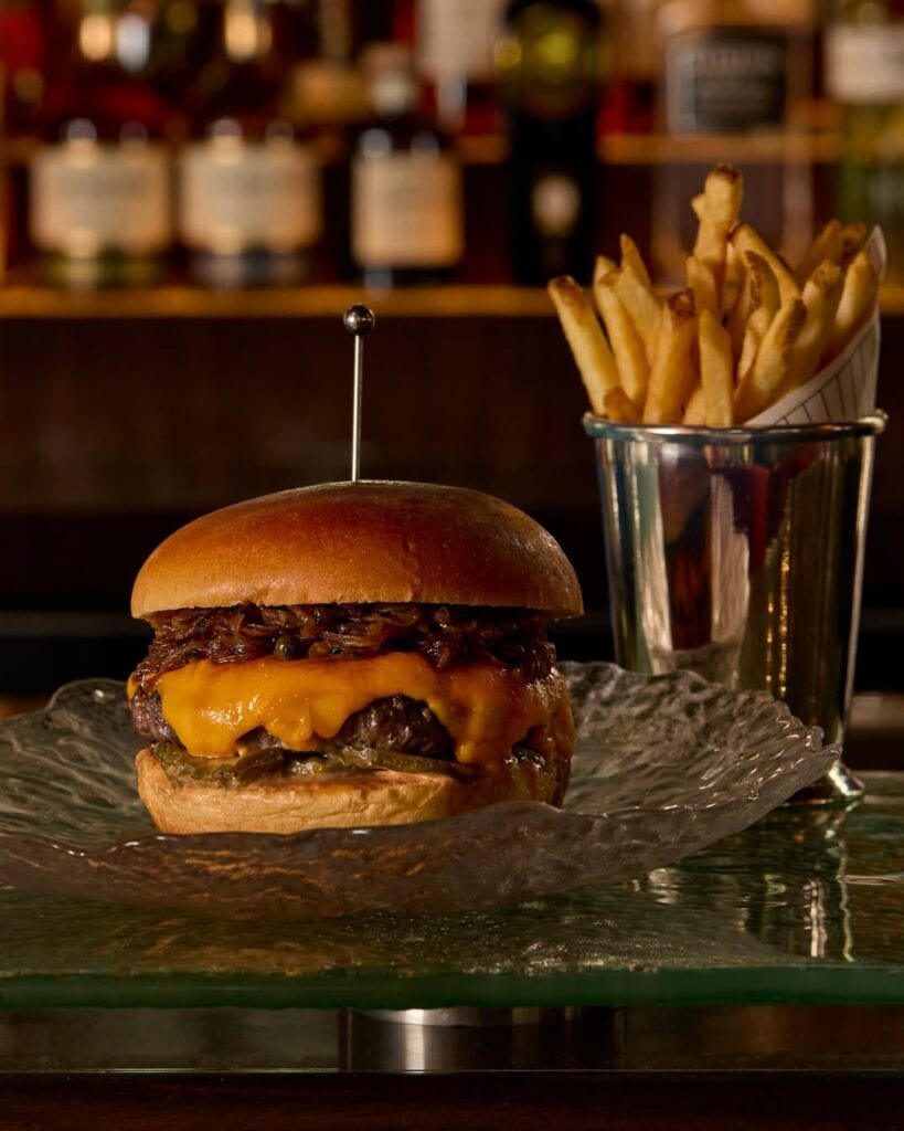 O'Connor beef burger with Hennessy XO flambeed onions aged cheddar American cheese and fries at The International Sydney CBD