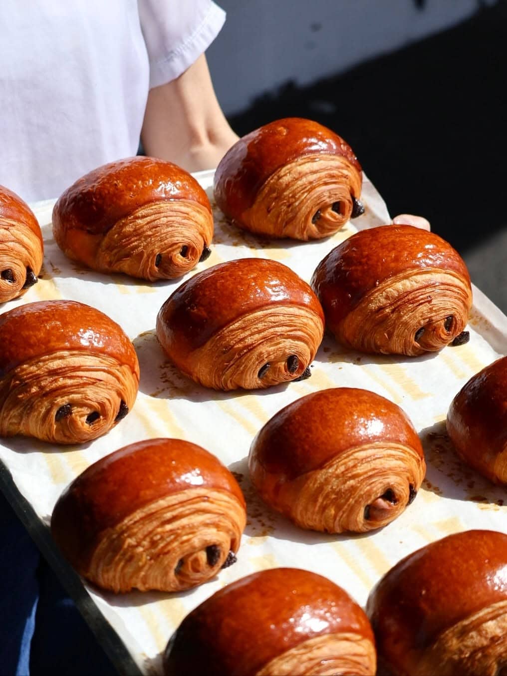 Freshly baked pain au chocolat on a tray at Calle Bakery, one of Melbourne’s popular pastry spots.