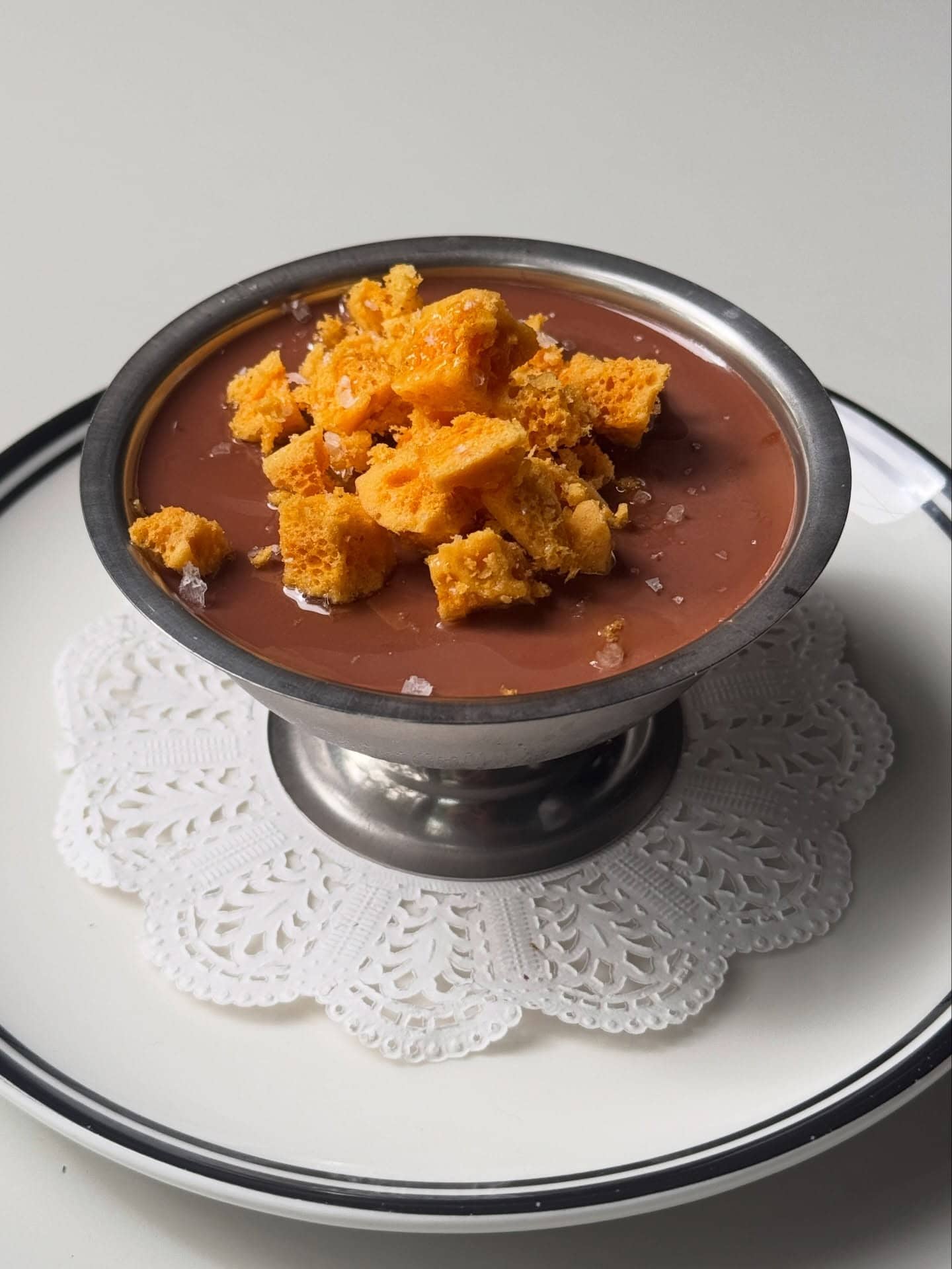 a silver vessel full of chocolate mousse and topped with honeycomb atop a doiley at fabbrica in sydney