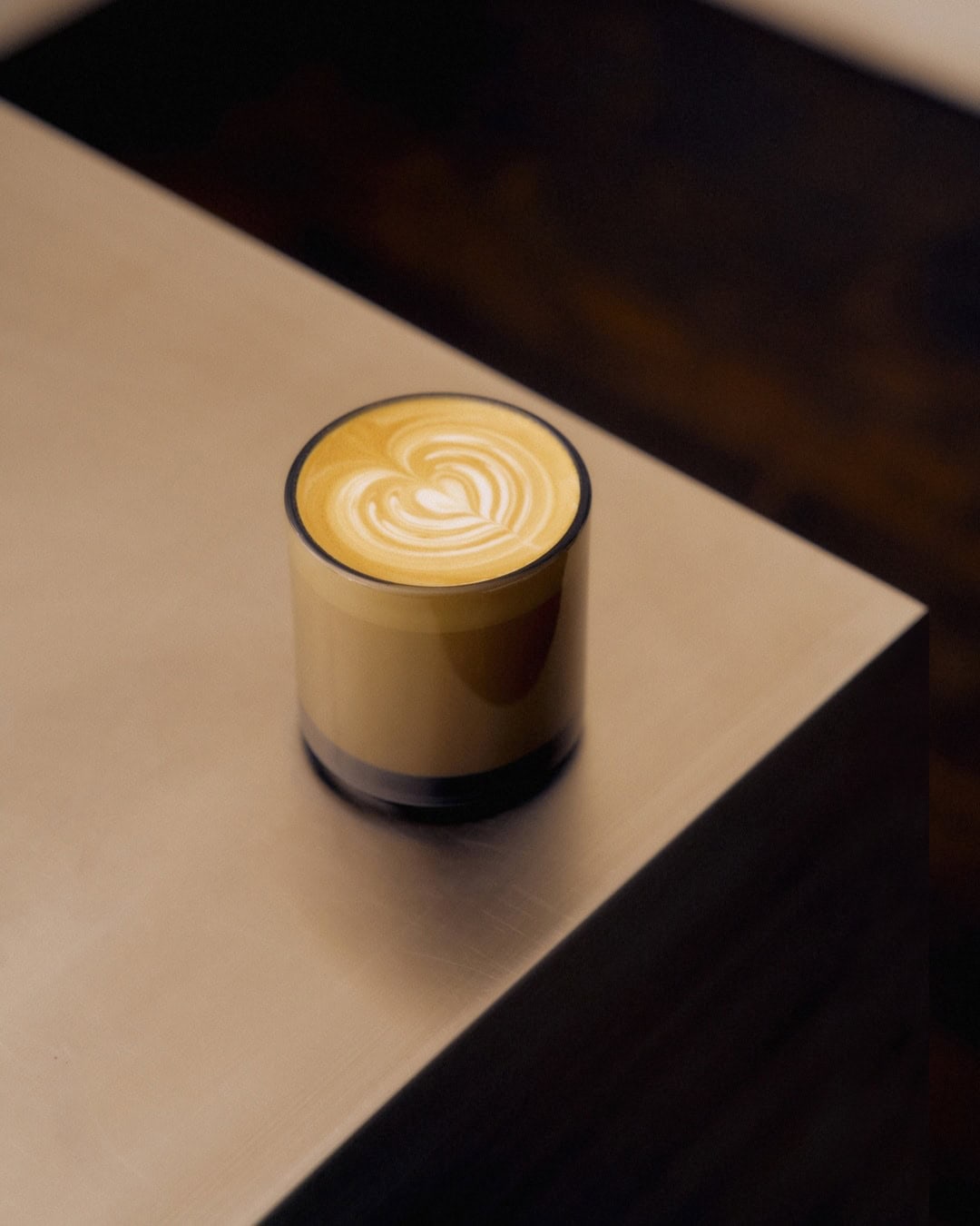 A latte from Skittle Lane sitting on the corner of a coffee table.