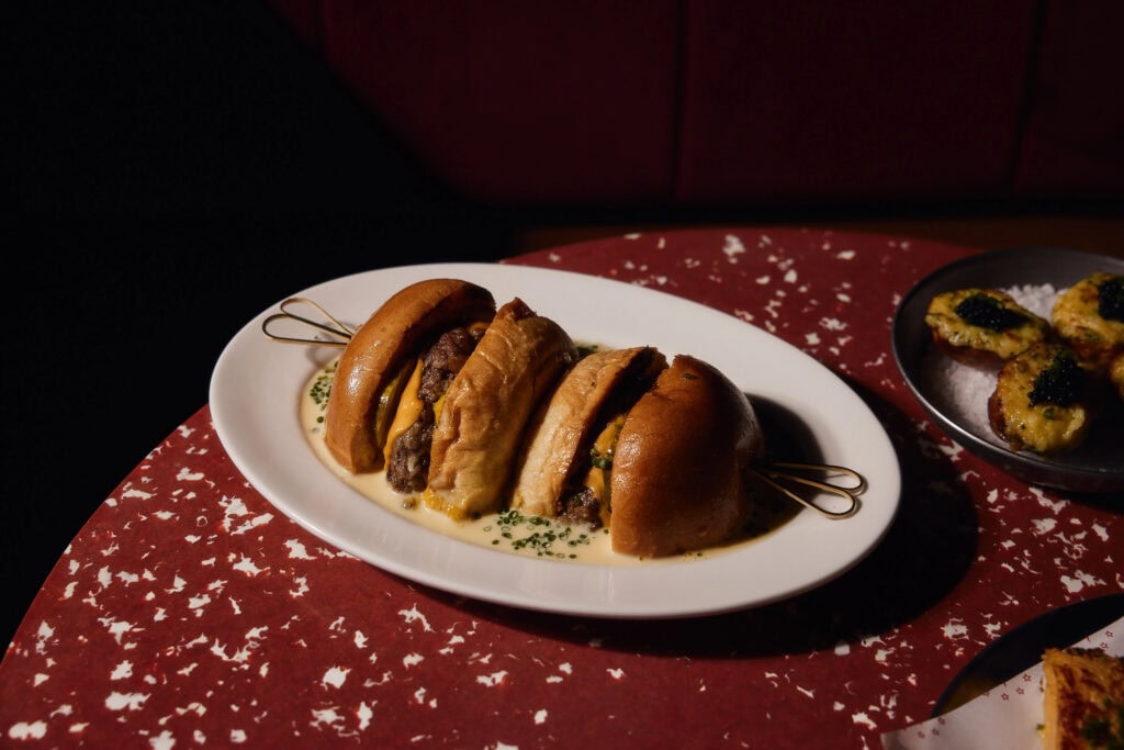 Dirty Royale wagyu cheeseburger with Red Leicester and cheese fondue served on terrazzo table at Razz Room Sydney CBD