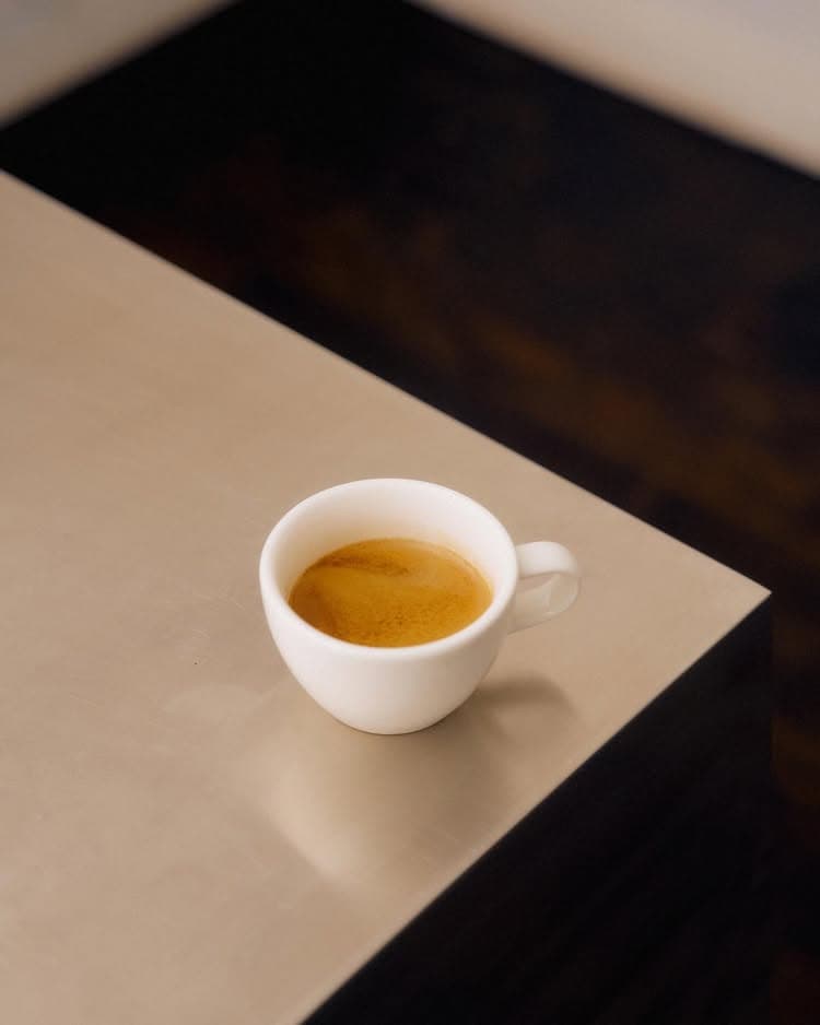 A full espresso cup on the corner of a table at Skittle Lane in Sydney.