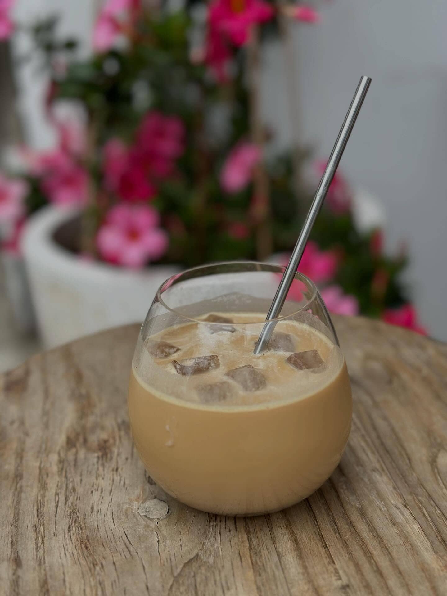 An iced coffee in a glass cup with a silver straw in it from broth bar and larder in bronte.