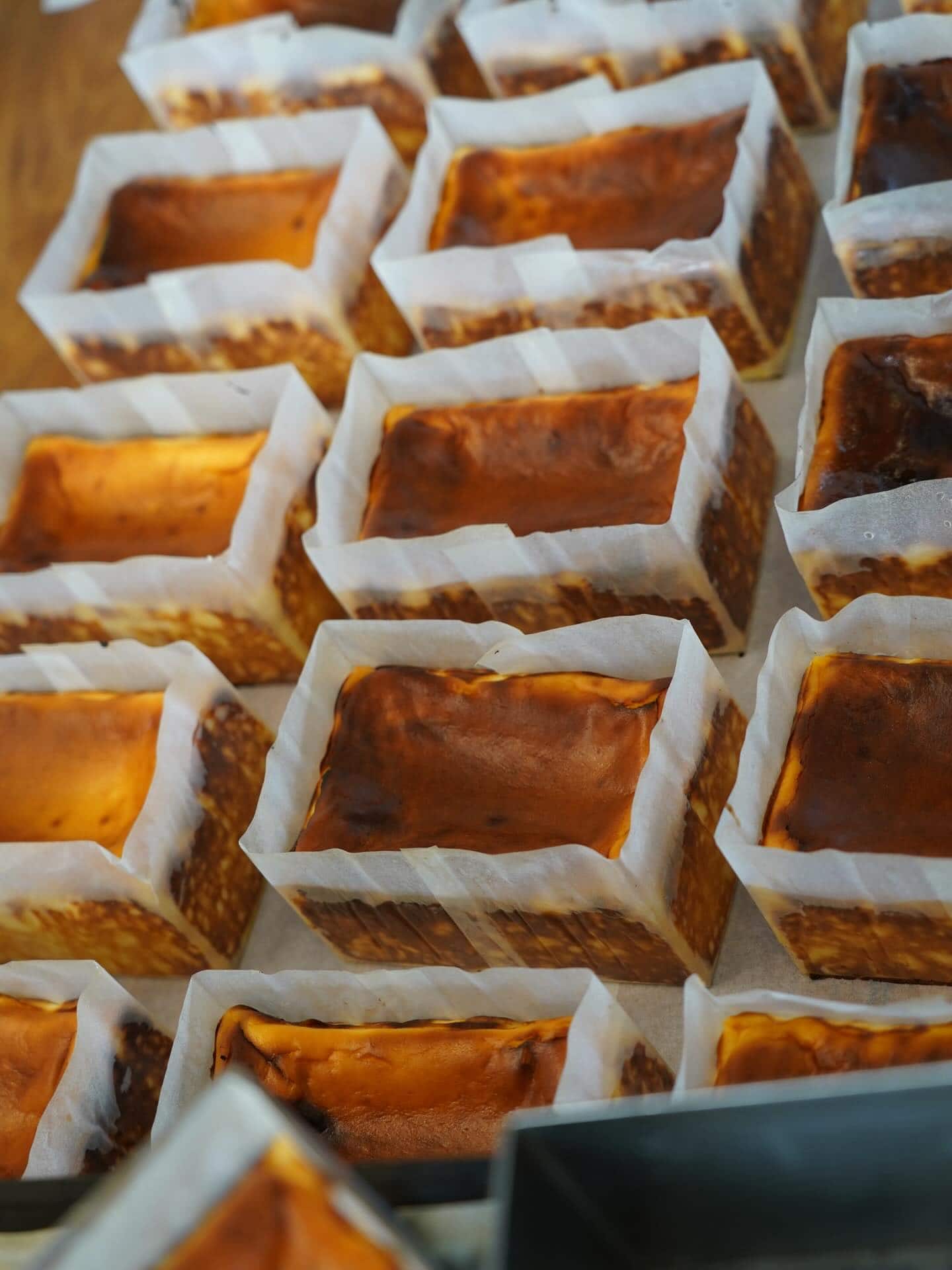 Rows of individual Basque cheesecakes cooling at Lulu & Me in Collingwood, Melbourne.