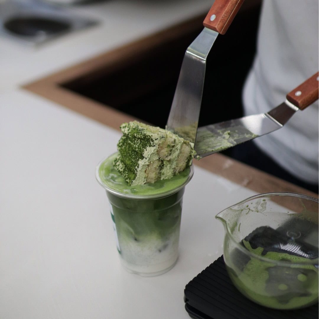 Matchamisu dessert being placed on iced matcha drink at San Java 2.0 Surry Hills Sydney