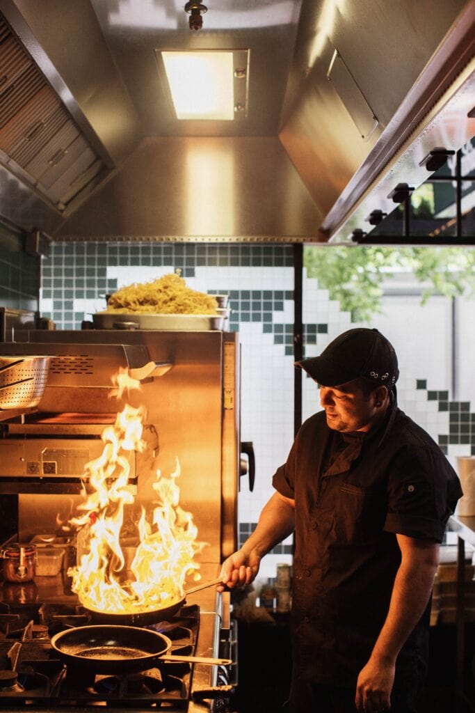 Chef cooking with fire at Cumbia Bar & Kitchen in Adelaide.