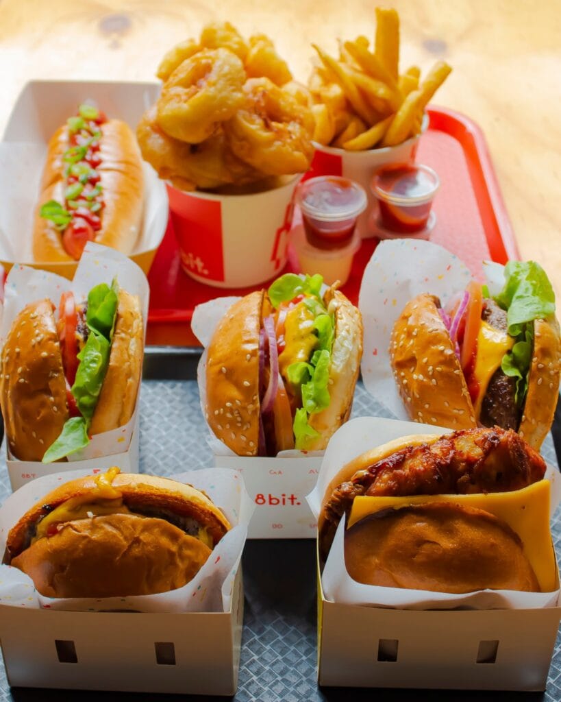 Selection of burgers, onion rings, fries, hot dog and sauces at 8bit Footscray burgers in Melbourne