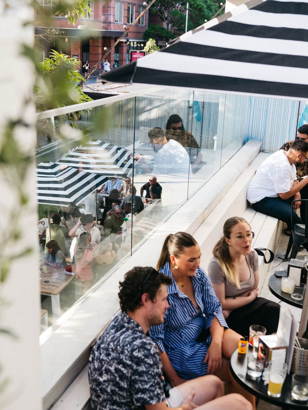 A group of people enjoying the sunshine on the balcony of the dolphin in surry hills.