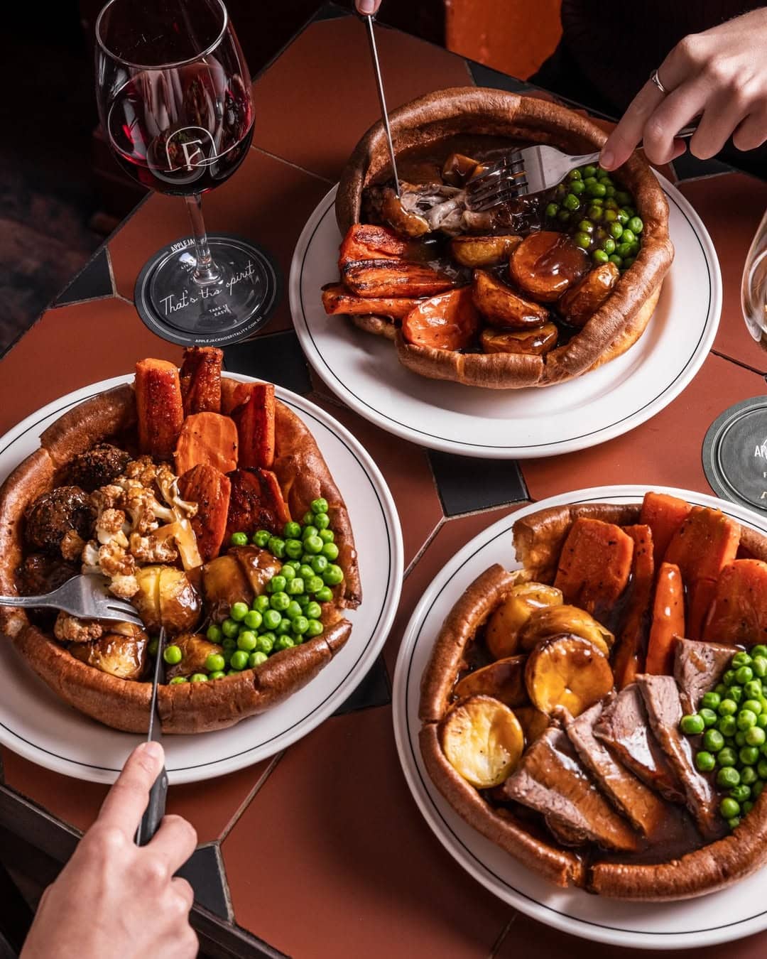 Three people tucking into giant yorkies at forresters pub in surry hills.