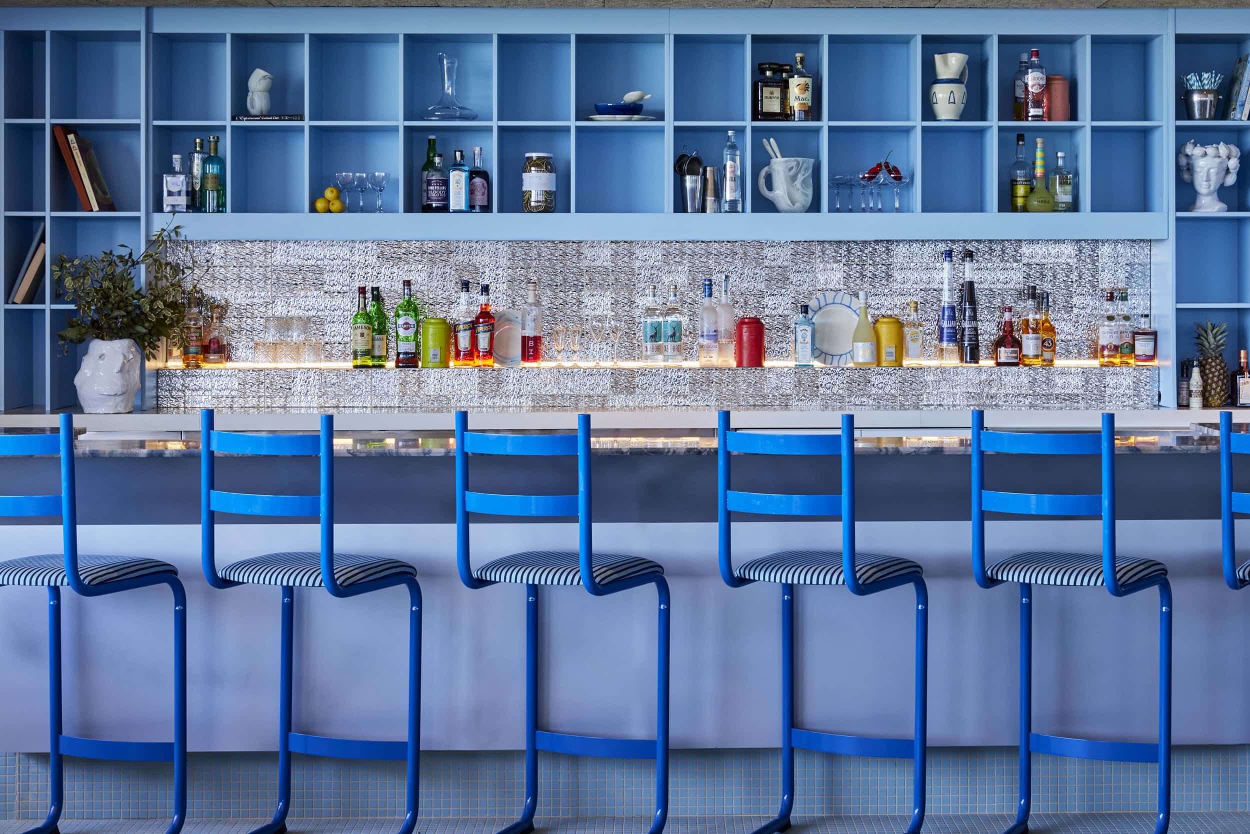 Blue bar stools with striped seats and silver mosaic splashback at Summer Salt Cronulla Sydney