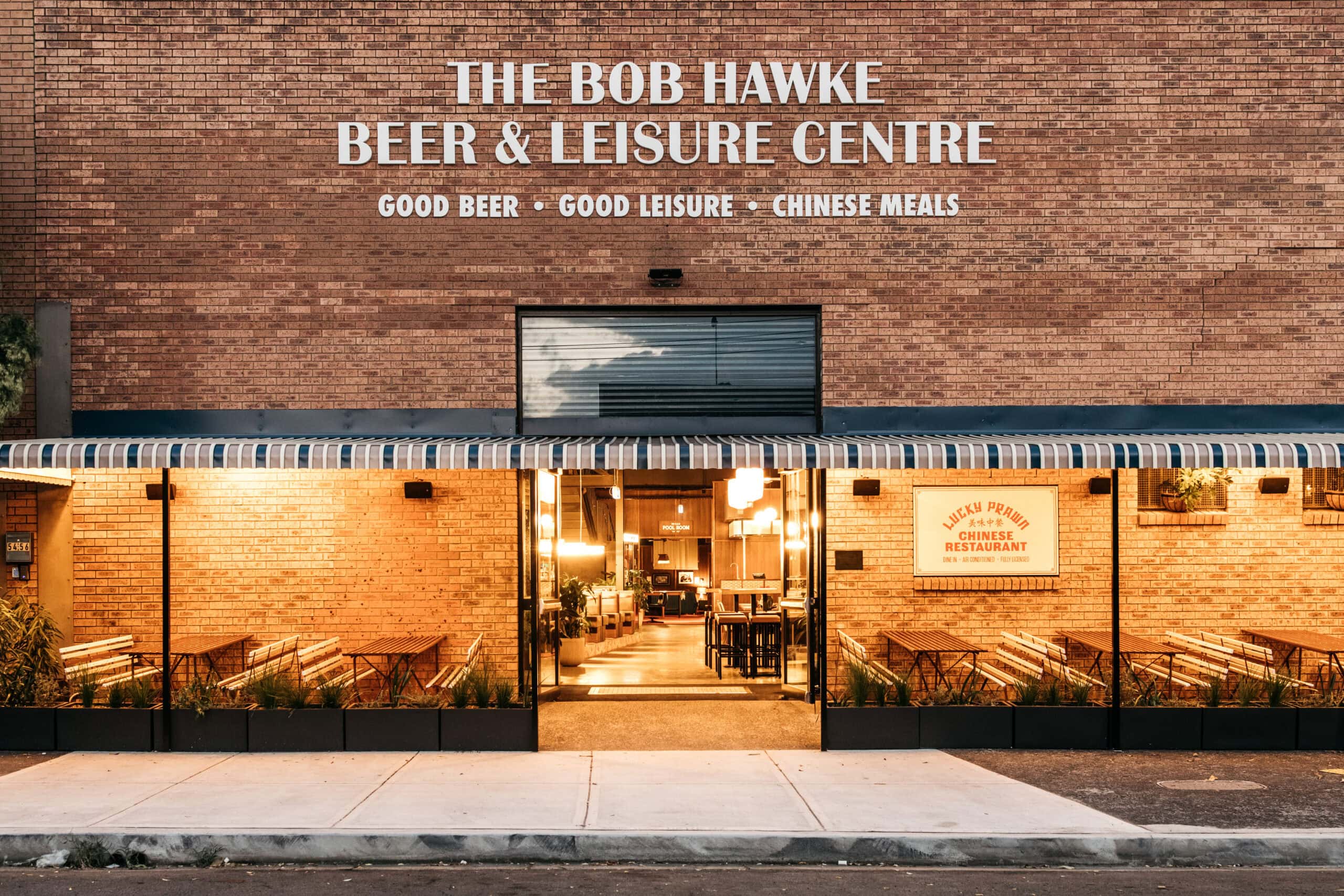 Brick facade entrance with striped awning and Lucky Prawn Chinese Restaurant signage at The Bob Hawke Beer and Leisure Centre Newtown Sydney